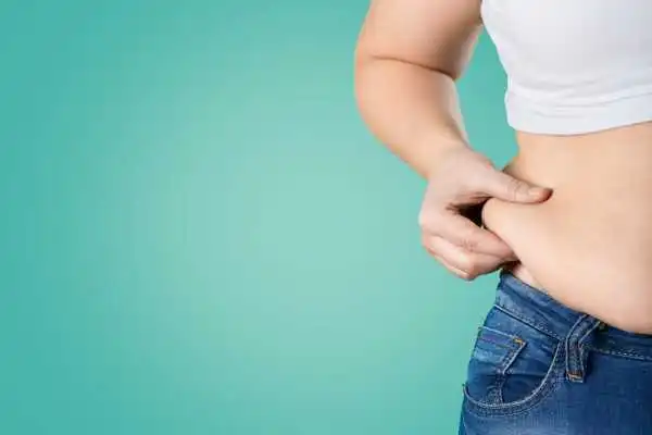 Image of woman pinching her love handles to show weight gain Newton Mearns